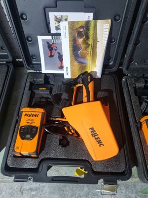 deux outils orange et noirs dans un coffret posé par terre