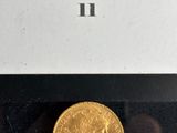 a close up of a gold coin in a box on a table