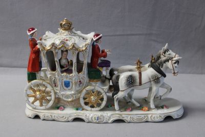 a figurine of a horse drawn carriage with people on it