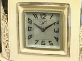 a white clock that is sitting on a table
