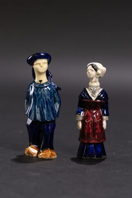 deux figurines représentant des personnes debout l'une à côté de l'autre sur une surface noire