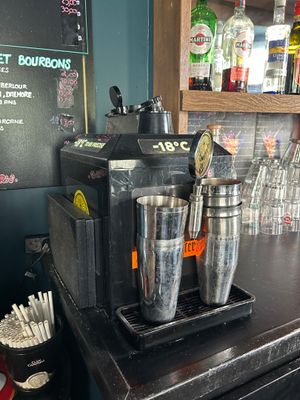 un comptoir noir sur lequel sont posées plusieurs tasses argentées