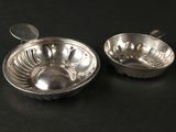 paire de bols plaqués argent avec cuillères, posés sur un support noir