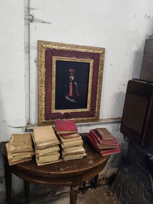 a table with books on it and a picture on the wall