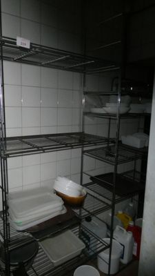a metal shelf with dishes on it in a kitchen