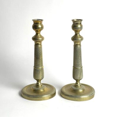pair of antique brass candlesticks on a white background