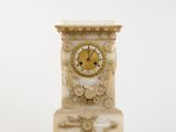 a white clock with a gold face on a stand