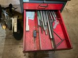 une boîte à outils rouge contenant des outils, dans un garage