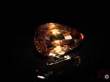 a close up of a large orange diamond on a black surface