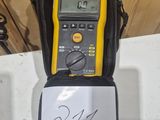 a yellow and black digital multimeter sitting on top of a black bag