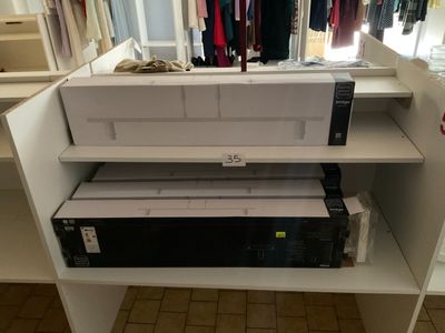 une étagère blanche sur laquelle se trouve une imprimante noir et blanc