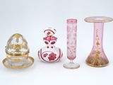 quatre vases différents et un petit œuf posés sur une table