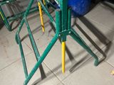 a green table with yellow legs on a tiled floor