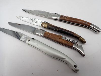 Quatre couteaux sont alignés sur une surface blanche ; l'un est muni d'un tire-bouchon et l'autre est muni d'un tire-bouchon.