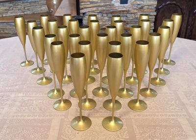 a lot of gold wine glasses sitting on a table