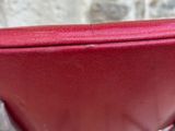 a red chair that is sitting in front of a stone wall