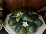 some cucumbers are on a white plate on a wooden shelf