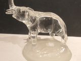 a clear glass elephant figurine on a white table