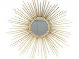 un miroir doré à rayons, accroché au mur