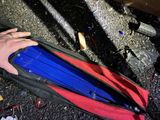 a person holding a blue and red object in a black bag