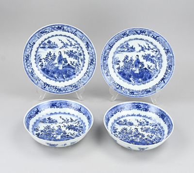 a set of four blue and white plates