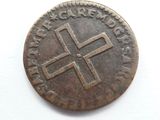an old coin with a cross on it sitting on a white surface