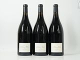 trois bouteilles de vin sont alignées sur une surface blanche