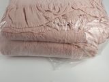 a pile of folded pink blankets on a white table