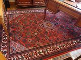 un tapis posé à même le sol dans une pièce où se trouvent un bureau et une chaise
