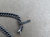 a close up of a silver chain on a brown surface