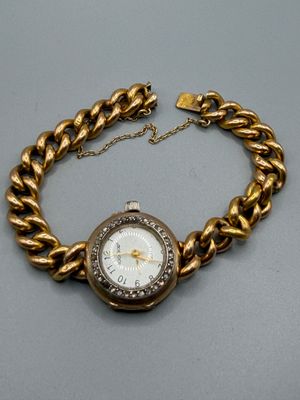 une image représentant une montre-bracelet en or entourée d'une chaîne
