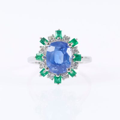 a close up of a blue sapphire and diamond ring on a white background