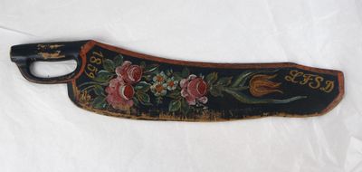 une image représentant un couteau en bois orné d'un motif floral