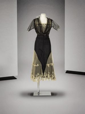 une robe noire et blanche posée sur un mannequin dans une pièce
