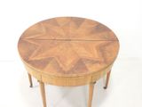 a small round table with a wooden top on a white floor