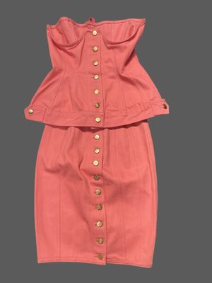 an image of a pink dress with buttons on the shoulders