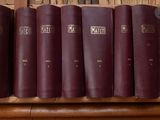 several books are lined up on a shelf in front of a bookshelf