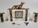 a clock with a dog statue on top of it