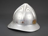 silver helmet with red and yellow buttons on it on a gray background