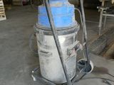 un aspirateur bleu et blanc posé sur un chariot dans un entrepôt