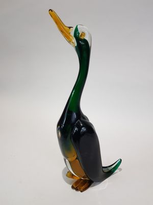 a glass duck that is sitting on a white surface