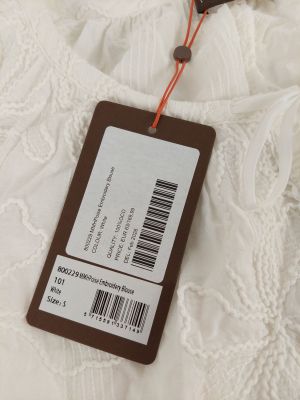 the label of a white dress is attached to a brown tag