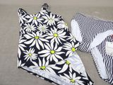 a black and white bathing suit with a yellow flower on it