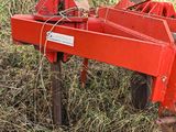 a red plow sitting in the middle of a field