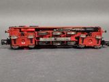a red train on the tracks on a gray surface