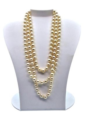 un gros plan d'un collier orné de perles porté par un mannequin