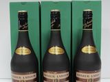 three bottles of wine sitting on top of a table next to a green box
