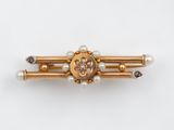 une image représentant une broche en or et perles, ornée de perles