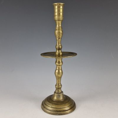 an antique brass candle holder with two candles on top of it
