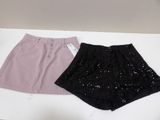 two pairs of shorts with sequins on them sitting on a table